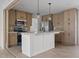 Kitchen with island, stainless appliances, pendant lights, and light wood cabinets at 909 Pine Thicket St., Myrtle Beach, SC 29577