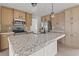 Close-up of kitchen island with gray countertops, stainless steel appliances, and light cabinets at 909 Pine Thicket St., Myrtle Beach, SC 29577