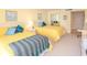 Bright bedroom featuring two beds with yellow bedding, a dresser, and a comfortable office chair at 9820 Queensway Blvd. # 1210, Myrtle Beach, SC 29572