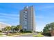 Stunning exterior view of a high-rise condo building with balconies and manicured landscaping in a lush community at 9820 Queensway Blvd. # 1210, Myrtle Beach, SC 29572