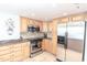 Well-lit kitchen with stainless steel appliances and light wood cabinets at 9820 Queensway Blvd. # 1210, Myrtle Beach, SC 29572