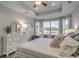 Serene main bedroom showcasing a tray ceiling, large windows with great views, and stylish furnishings at 191 Glengrove Lane, Murrells Inlet, SC 29576