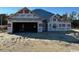 An unfinished single-Gathering home with a two-car garage on a sandy lot at 6242 Old Bucksville Rd., Conway, SC 29527