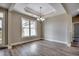 Bright dining room featuring wood-look floors, modern light fixture, and large windows at 646 Sunny Pond Ln., Aynor, SC 29511