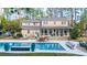 Lovely backyard pool with outdoor dining, seating and a large two-story house surrounded by trees at 133 Otter Run Rd., Pawleys Island, SC 29585