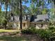 Charming home featuring dormer windows, a well-manicured lawn, and lush greenery at 133 Otter Run Rd., Pawleys Island, SC 29585