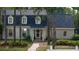 Lovely two-story home with dormer windows, and a brick walkway framed by trees and landscaping at 133 Otter Run Rd., Pawleys Island, SC 29585
