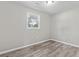 An empty bedroom with wood-look floors is brightened by a window view to the outdoors at 746 Gumbo Limbo Ln., Myrtle Beach, SC 29579