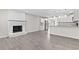 Open concept living space featuring modern flooring, a brick fireplace, and a view of the updated kitchen at 746 Gumbo Limbo Ln., Myrtle Beach, SC 29579
