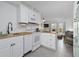 Bright kitchen with white cabinetry, modern appliances and seamless flow to the living room at 1 Norris Dr. # 249, Pawleys Island, SC 29585