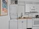 Well-equipped kitchen with laundry space, butcher block countertops and modern white appliances at 1 Norris Dr. # 249, Pawleys Island, SC 29585