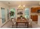 Staged dining area featuring a wooden table, chairs, and adjacent doors to a tiled sunroom at 1001 Cardinal Ct., Murrells Inlet, SC 29576