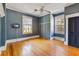 Bright bedroom featuring two windows, hardwood floors, ceiling fan and a dark blue accent wall at 103 N Magnolia Ave., Andrews, SC 29510