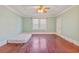 Spacious bedroom with hardwood floors, neutral paint, and a window providing natural light at 103 N Magnolia Ave., Andrews, SC 29510