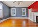 Spacious bedroom with hardwood floors, three windows for natural light, and decorative fireplace at 103 N Magnolia Ave., Andrews, SC 29510