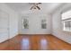 Bright, spacious bedroom featuring hardwood floors, three windows for abundant natural light, and a ceiling fan at 103 N Magnolia Ave., Andrews, SC 29510
