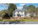Traditional two-story house with tidy landscaping, brick fence, and red door at 103 N Magnolia Ave., Andrews, SC 29510