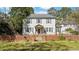Charming two-story home with a brick fence and shuttered windows surrounded by mature trees at 103 N Magnolia Ave., Andrews, SC 29510