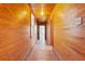 Long hallway featuring wood-paneled walls and hardwood floors, leading to rooms with ample light at 103 N Magnolia Ave., Andrews, SC 29510