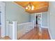 Light-filled hallway with hardwood floors, white banister, and wooden ceiling detail at 103 N Magnolia Ave., Andrews, SC 29510