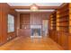 Living room with wood paneling, a fireplace, and built-in shelves at 103 N Magnolia Ave., Andrews, SC 29510