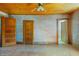 Room with multiple doors, rustic walls, hardwood flooring, and a ceiling fan at 103 N Magnolia Ave., Andrews, SC 29510