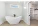 Modern bathroom with a freestanding tub, walk-in closet, and light wood floors at 105 Serenity Point Dr., Little River, SC 29566