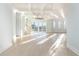 Expansive room featuring tray ceilings, ample sunlight, hardwood floors, and access to outdoor views at 105 Serenity Point Dr., Little River, SC 29566