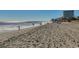 Beautiful sunny beach view with people enjoying the sand and surf, and condo buildings in the distance at 107 S Ocean Blvd. # 1407, Myrtle Beach, SC 29577