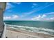 Expansive ocean views from a high-rise balcony, featuring a sandy beach and a distant pier at 107 S Ocean Blvd. # 1407, Myrtle Beach, SC 29577