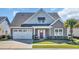 Charming home showcasing well-manicured landscaping, a two-car garage, and inviting front porch seating at 1109 Bonnet Dr., North Myrtle Beach, SC 29582
