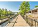 Picturesque boardwalk featuring dark metal railings, a wooden pathway, and lush natural surroundings at 1113 Green Fir Loop, Conway, SC 29527