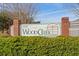 Woodcreek at Conway sign with manicured hedges, brick pillars, and an elegant aesthetic for a welcoming atmosphere at 1113 Green Fir Loop, Conway, SC 29527