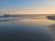 Sunset view of a pier extending over a peaceful beach at 1151 Silver Perch Place, Sunset Beach, NC 28468