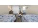 Cozy bedroom featuring two twin beds, nautical decor, and a beach-themed area rug on wood-look floors at 121 Osprey Watch Circle # 9-C, Pawleys Island, SC 29585