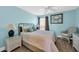 Comfortable bedroom with blue walls, a crab painting, and wicker furniture at 121 Osprey Watch Circle # 9-C, Pawleys Island, SC 29585