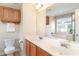 Bathroom featuring dual sinks, white countertop, wood cabinets, and a large mirror at 1268 Brighton Ave., Myrtle Beach, SC 29588