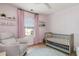 Charming Bedroom with crib, rocker, pink curtains, and patterned wallpaper at 1268 Brighton Ave., Myrtle Beach, SC 29588