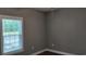 Simple bedroom featuring gray walls, a ceiling fan, dark hardwood floors, and a large window at 1415 Gooseneck Place # 101, Murrells Inlet, SC 29576