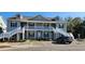Attractive, two-story condo with gray siding, white trim, dormer windows, and inviting staircases leading to elevated porches at 1415 Gooseneck Place # 101, Murrells Inlet, SC 29576