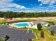 Community pool area showcasing a pool, clubhouse, parking, and nearby pond at 1415 Gooseneck Place # 101, Murrells Inlet, SC 29576