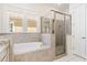 Bright bathroom with a soaking tub, glass-enclosed shower, and neutral tile work, creating a spa-like experience at 1423 Peterson St., Myrtle Beach, SC 29577