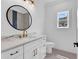 Elegant bathroom with a round mirror, marble countertop, white vanity, and striking gold fixtures at 144 Sago Palm Dr., Myrtle Beach, SC 29579