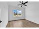 Bright bedroom featuring wood-look flooring, a modern ceiling fan, and a window with a neighborhood view at 144 Sago Palm Dr., Myrtle Beach, SC 29579