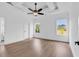 Bright main bedroom featuring hardwood floors, a ceiling fan, a tray ceiling, and many windows at 144 Sago Palm Dr., Myrtle Beach, SC 29579