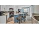 A kitchen featuring a blue island with barstools, white cabinets, and stainless steel appliances at 1500 Cenith Dr. # E302, North Myrtle Beach, SC 29582