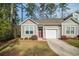 Charming single-story home with a red door, attached garage, and a well-maintained lawn surrounded by mature trees at 164 Vineyard Place # 23, Pawleys Island, SC 29585