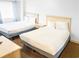 This bright bedroom offers two comfortable beds, a nightstand, neutral decor, and an inviting atmosphere at 205 74Th Ave. N # 904, Myrtle Beach, SC 29572