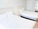 This bedroom is furnished with two beds, nightstand and mirror, with white linens and clean, neutral decor at 205 74Th Ave. N # 904, Myrtle Beach, SC 29572
