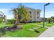 This exterior of the building is surrounded by lush landscaping and palm trees at 213 Landing Rd. # F, North Myrtle Beach, SC 29582